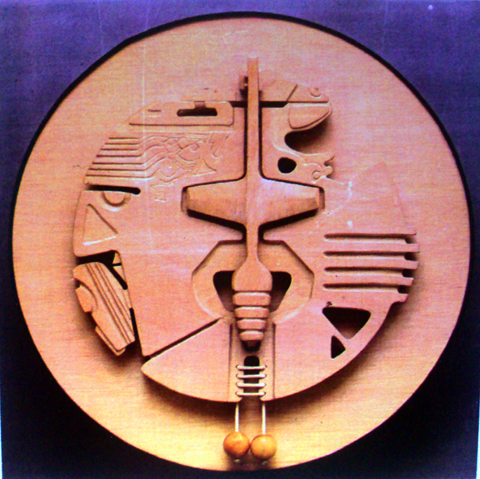 Escultopintura de Romero D. Fran: relieve circular de madera con formas geométricas talladas y dos esferas colgantes